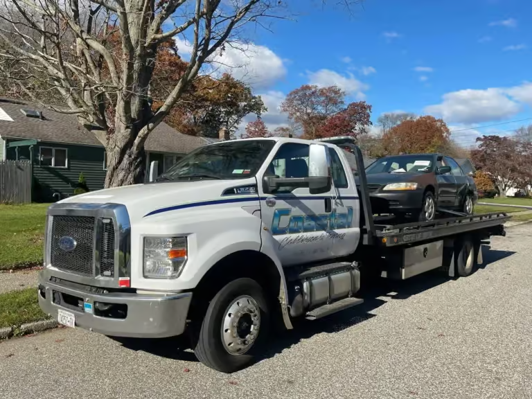 there is a truck that is parked on the street with a car on the back