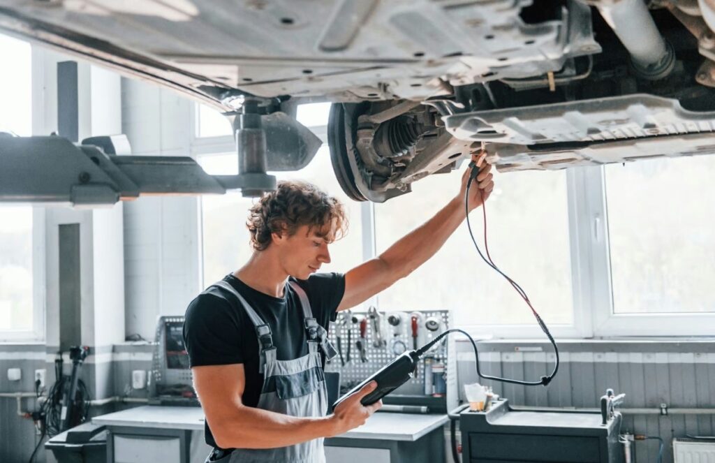 arafed man working on a car in a garage