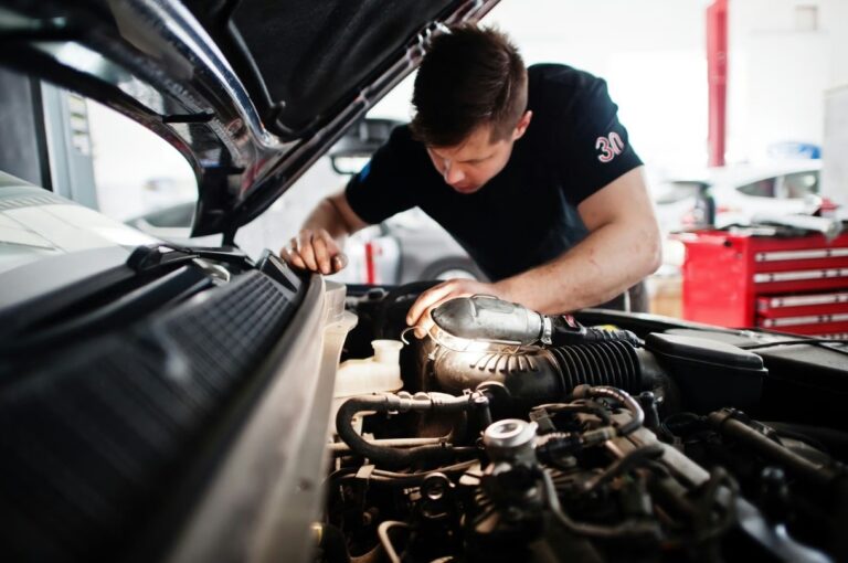 arafed man working on a car engine in a garage