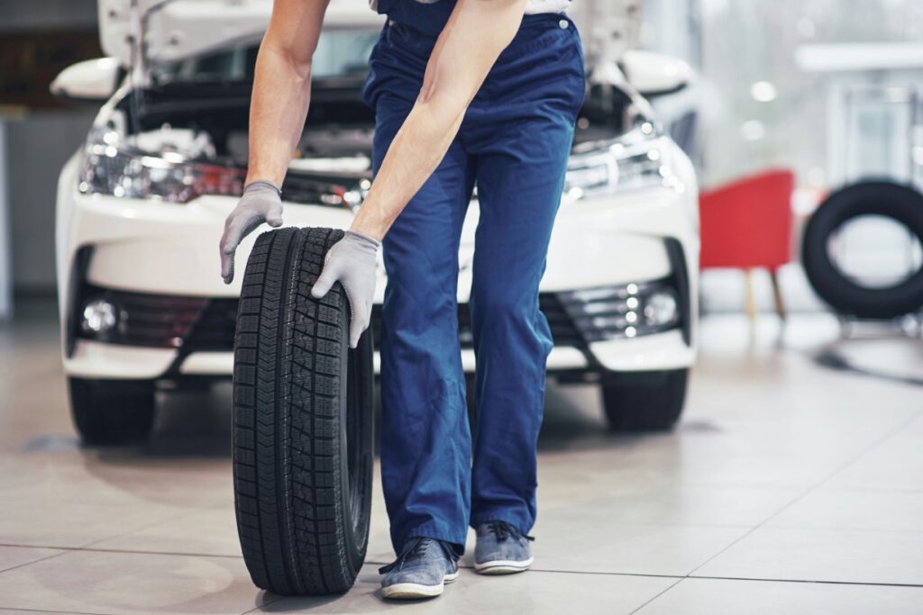 araffe mechanic working on a car tire in a garage