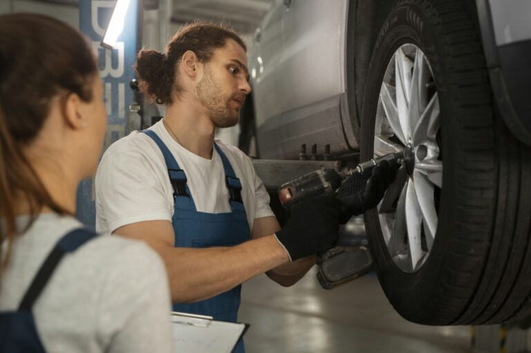 arafed man and woman working on a car in a garage