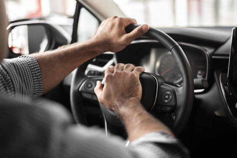 someone is driving a car with their hands on the steering wheel